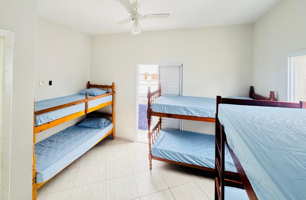 een kamer met 3 stapelbedden en een plafondventilator bij Martin de Sá-200 metros da praia in Caraguatatuba