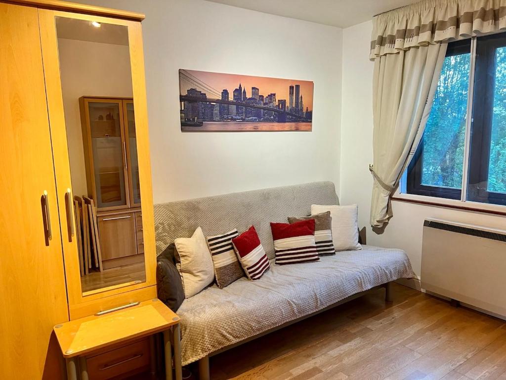 a living room with a couch with pillows on it at West-London minimalism with parking on premises in London