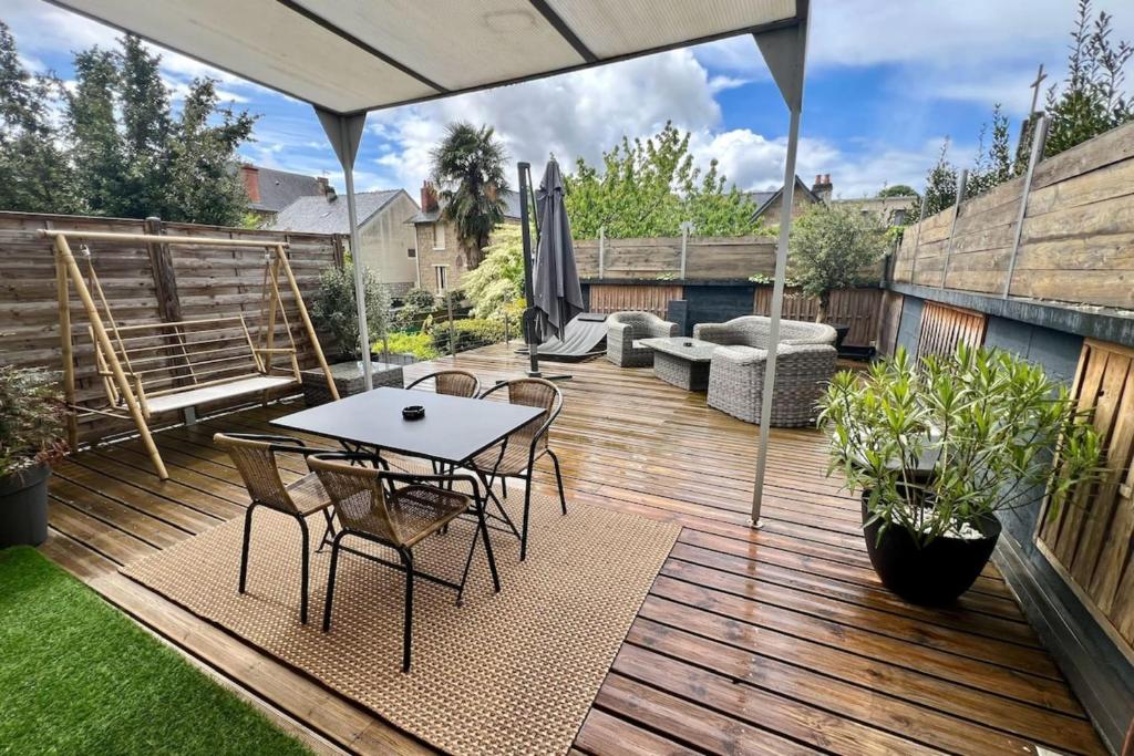 une terrasse en bois avec une table et des chaises. dans l'établissement Casa Jouvenel -T3 3 pers -Brive-Parking privatif, à Brive-la-Gaillarde