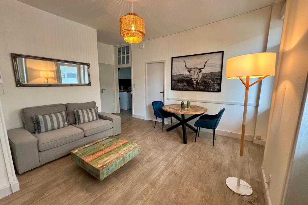 un salon avec un canapé et une table dans l'établissement Casa Grivel #1 - T2 avec Clim et Balcon - Centre Ville, à Brive-la-Gaillarde