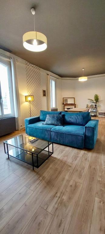un salon avec un canapé bleu et une table en verre dans l'établissement Casa Zola #2 - Grand T2 central avec balcon proche gare, à Brive-la-Gaillarde