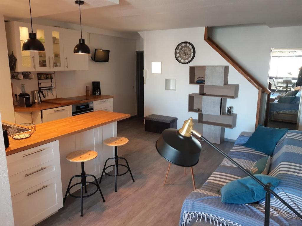 un salon avec un canapé et une cuisine dans l'établissement Vue sur les voiliers, à Gruissan