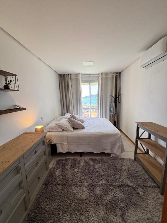 a bedroom with a large bed and a window at Vista inesquecível para o mar homeclub BetoCarrero in Penha