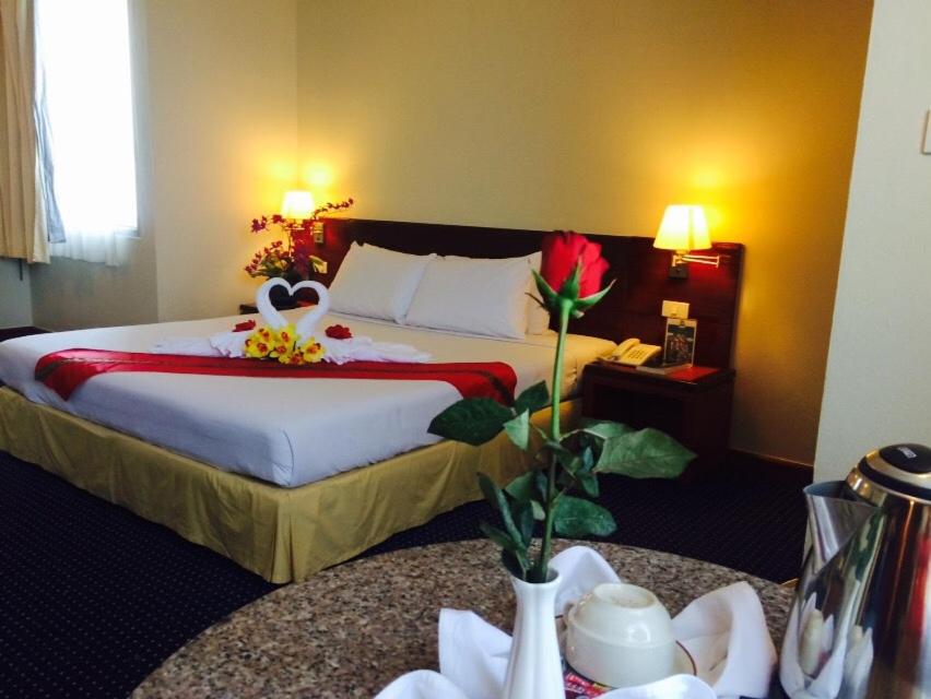 Hatyai Golden Crown Hotel في هات ياي: غرفه فندقيه بسرير وطاولتين