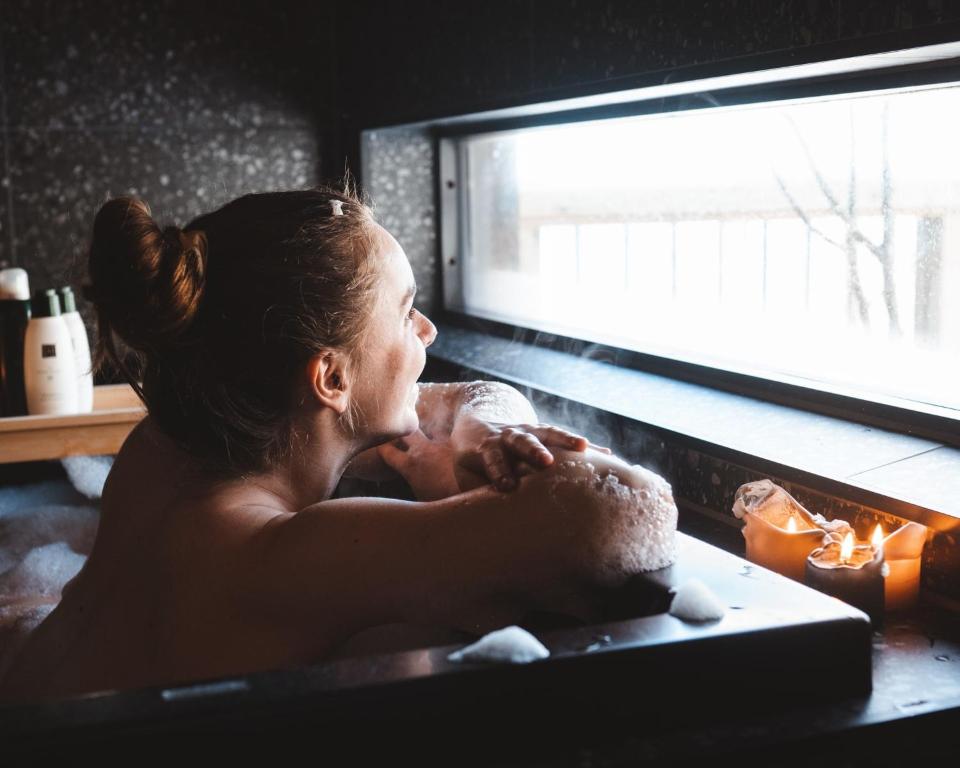 Una donna che fa il bagno in una vasca da bagno di Fuglekassehytta a Sparbu