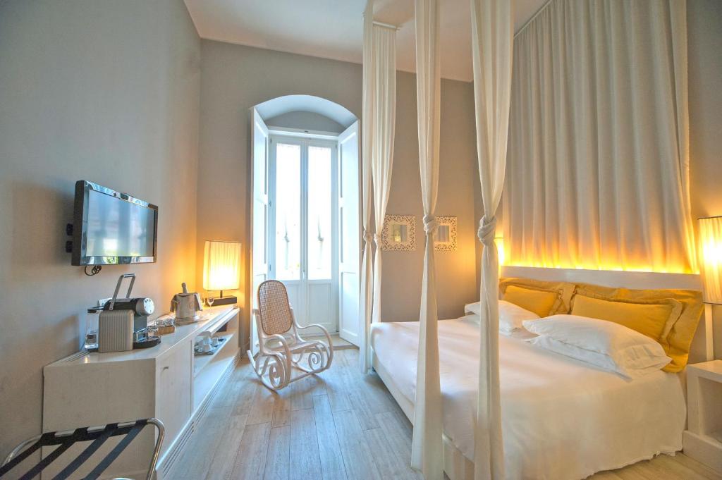 a bedroom with a white bed and a mirror at Le Stanze di Corteinfiore in Trani