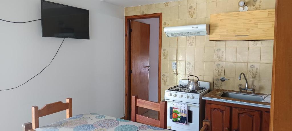 a small kitchen with a stove and a sink at El nuevo amanecer mar de ajó in Mar de Ajó