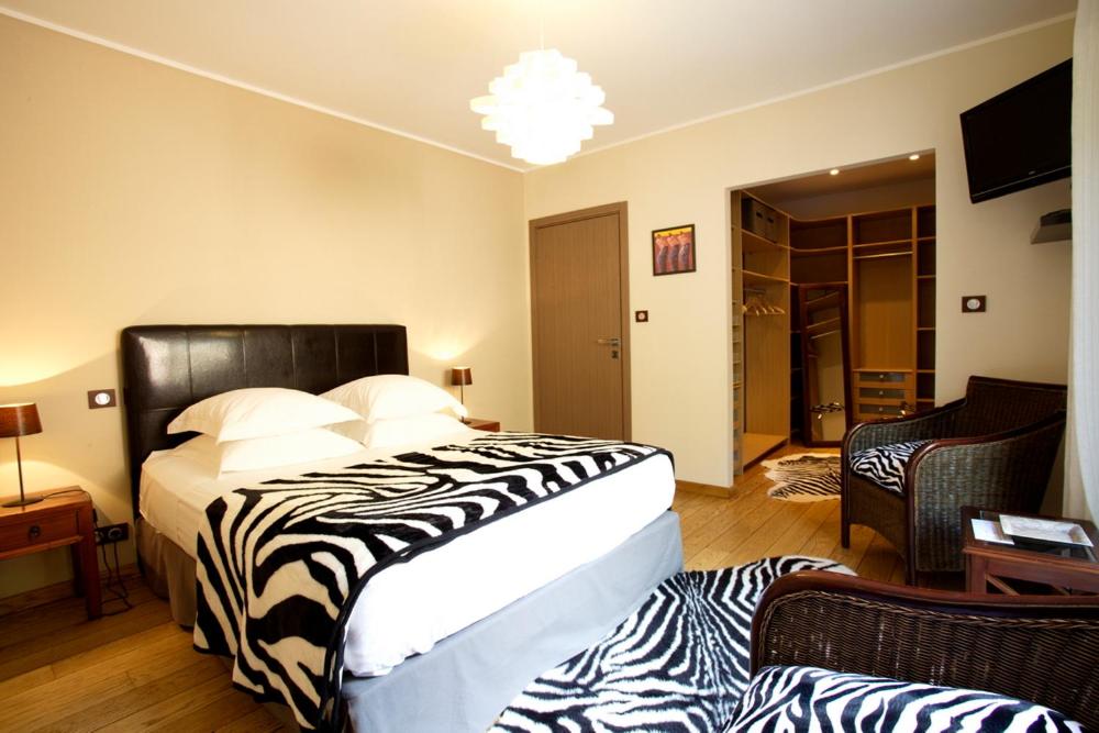 a bedroom with a zebra print bed and a living room at U Muzzelo in Oletta