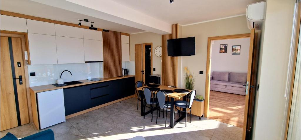 a kitchen and dining room with a table and chairs at Apartament Oliwia in Kluszkowce