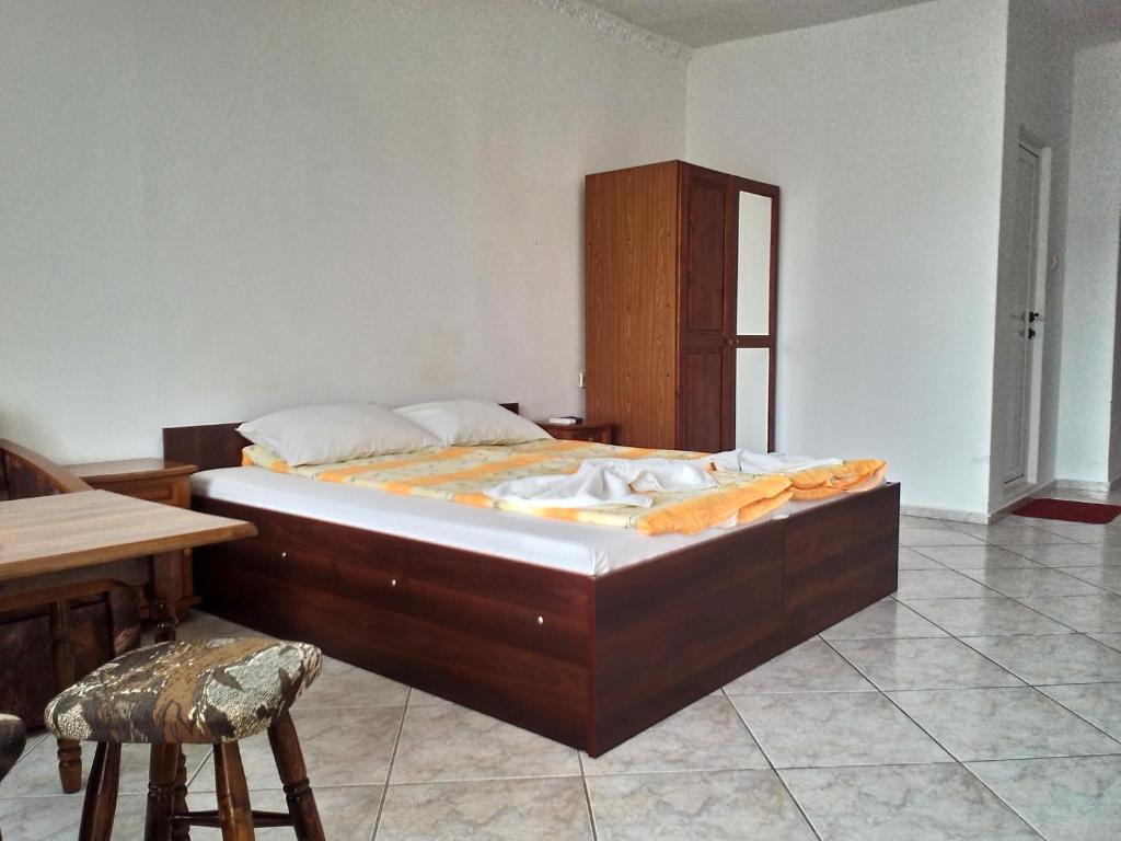 a large bed in a room with a table and chair at Guest House Diamant in Sozopol
