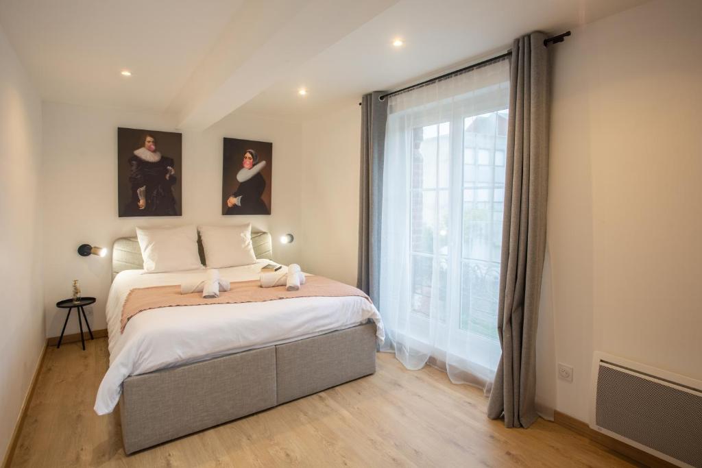 a bedroom with a bed and a large window at La promesse - T2 Hyper centre in Abbeville