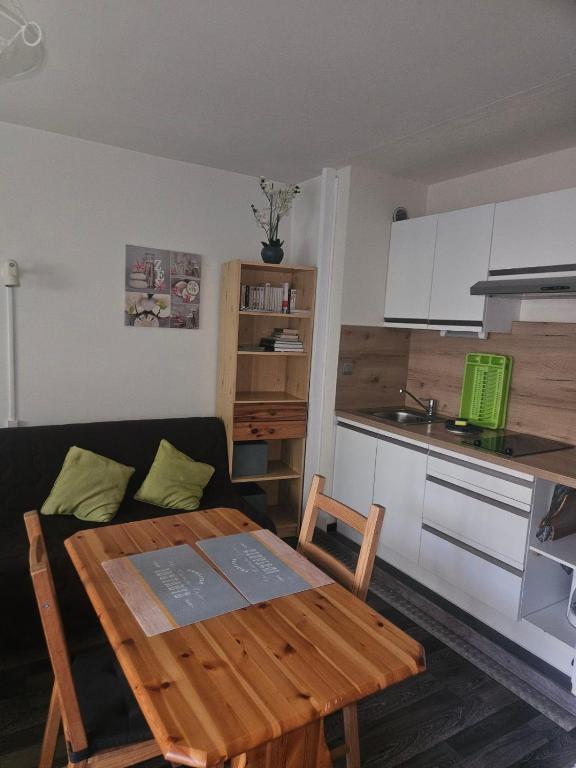 un salon avec une table et une cuisine dans l'établissement Comfortable furnished studio, à Aix-les-Bains