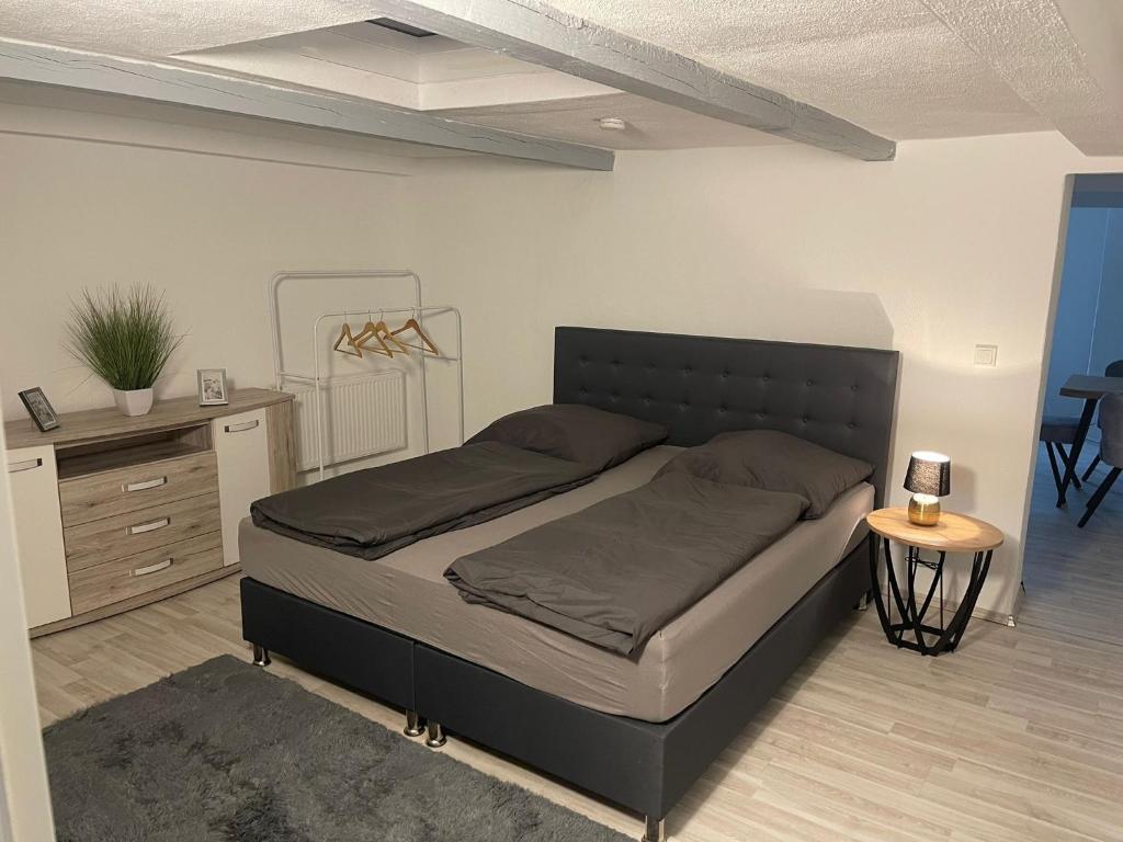 a bedroom with a bed and a dresser and a table at Appartment Schmidtner 2 in Ansbach