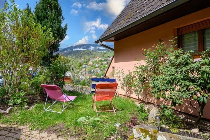 three chairs sitting in the grass next to a house at Logis en montagne chez Juju in Fréland