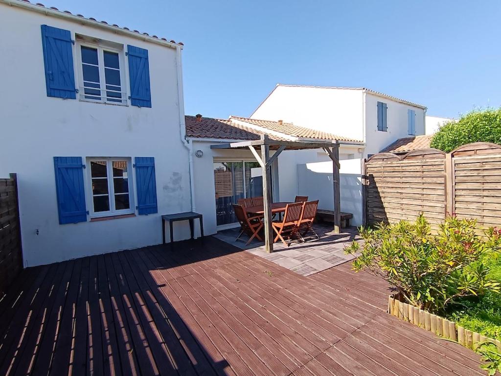 un patio avec une table et un parasol dans l'établissement linge fourni 3 etoiles Proche mer et centre ville, à Saint-Gilles-Croix-de-Vie