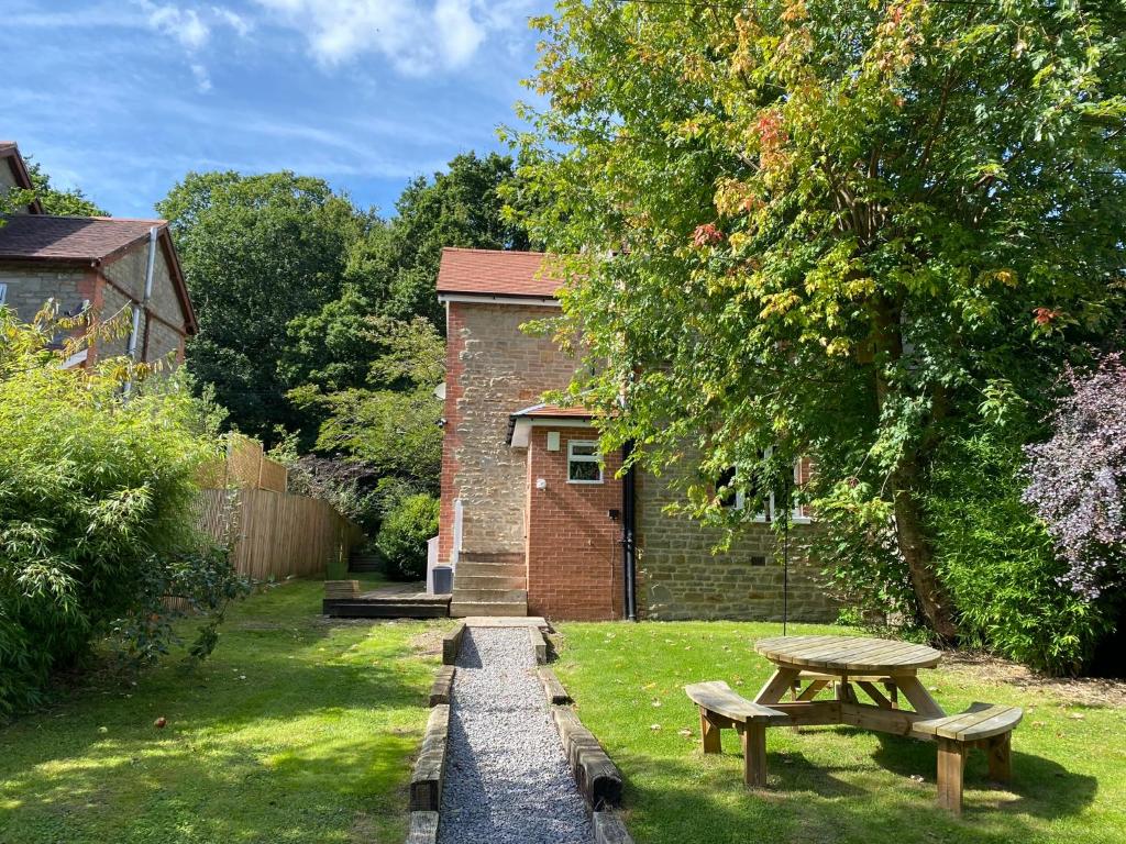a picnic table in the grass next to a building at Willow Cottage in Longney