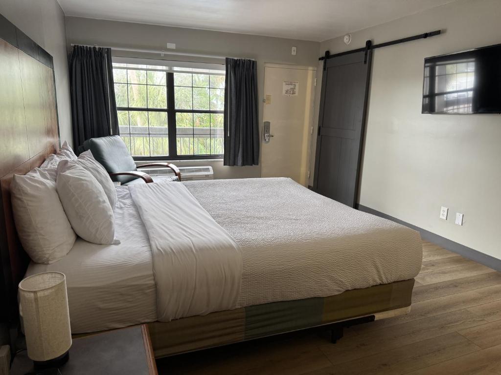 a bedroom with a large bed and a window at La Quinta Inn Tampa Airport Stadium Westshore in Tampa