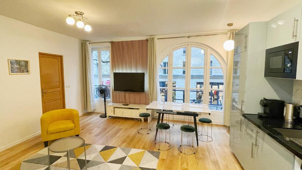un salon avec une table et une chaise jaune dans l'établissement Lux Home Le Marais, à Paris