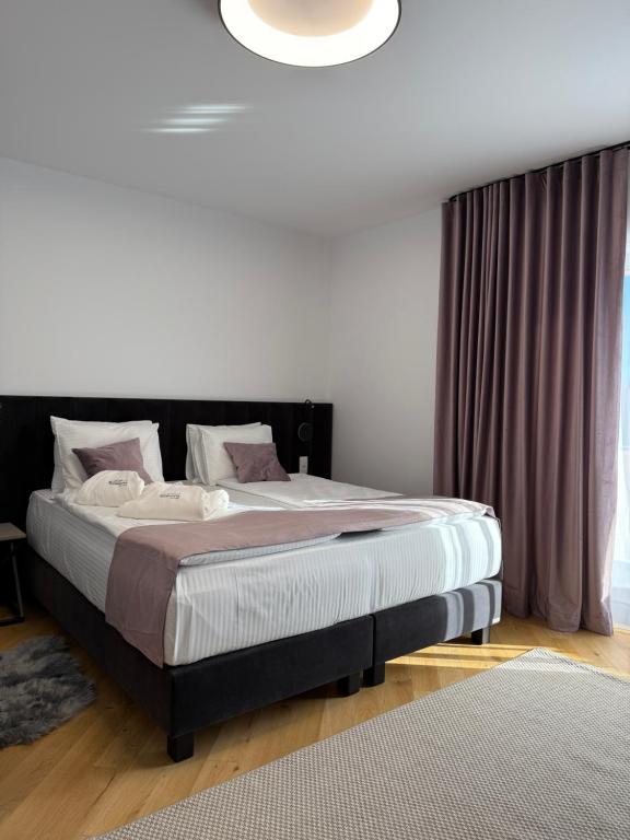 a bedroom with a large bed with a black headboard at Marmotta Paltinis in Păltiniş