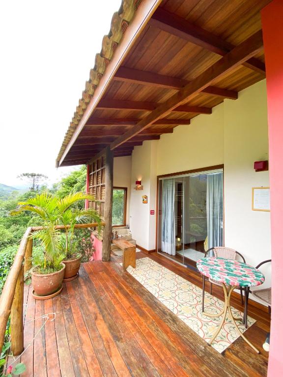 a porch of a house with a wooden deck at Chalé nas montanhas em São Francisco Xavier in São Francisco Xavier