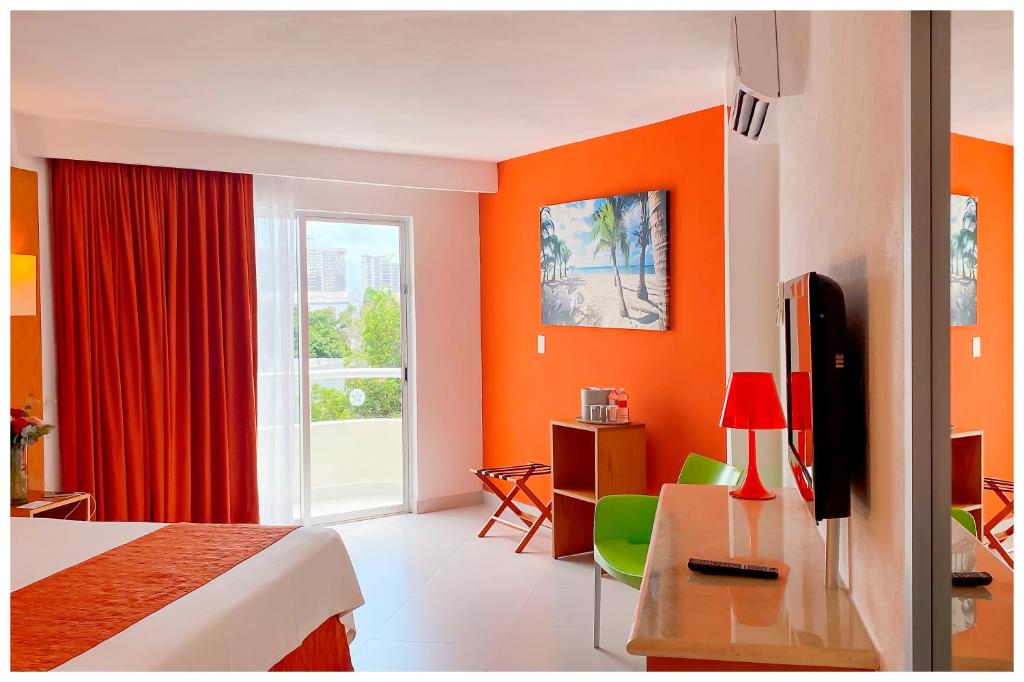 a hotel room with orange walls and a bed and a window at Adhara Express in Cancún