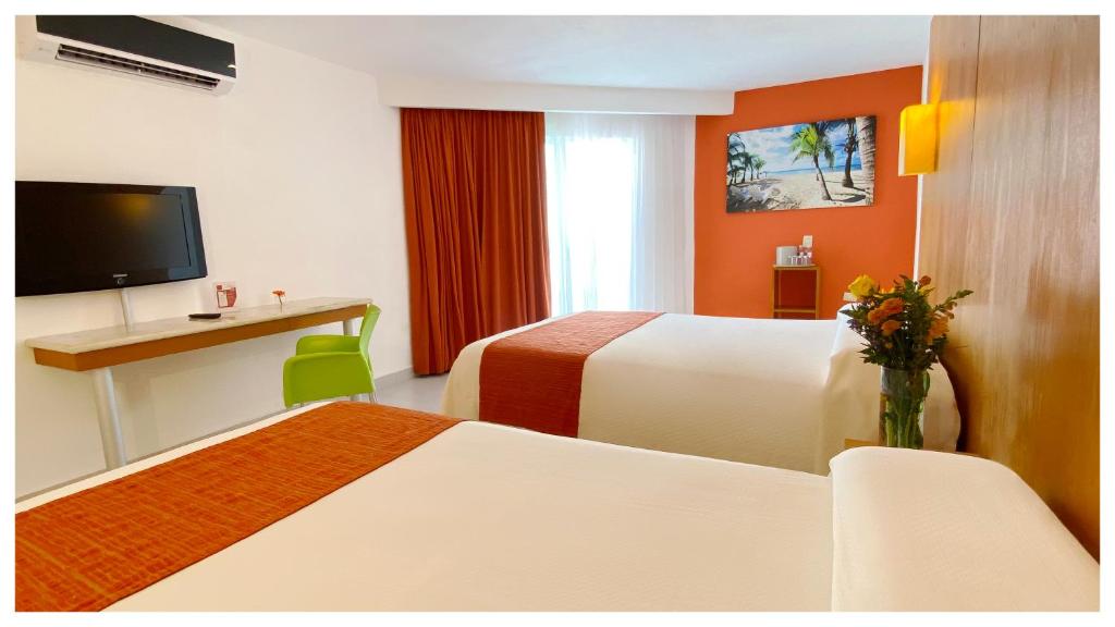 a hotel room with two beds and a desk at Adhara Express in Cancún