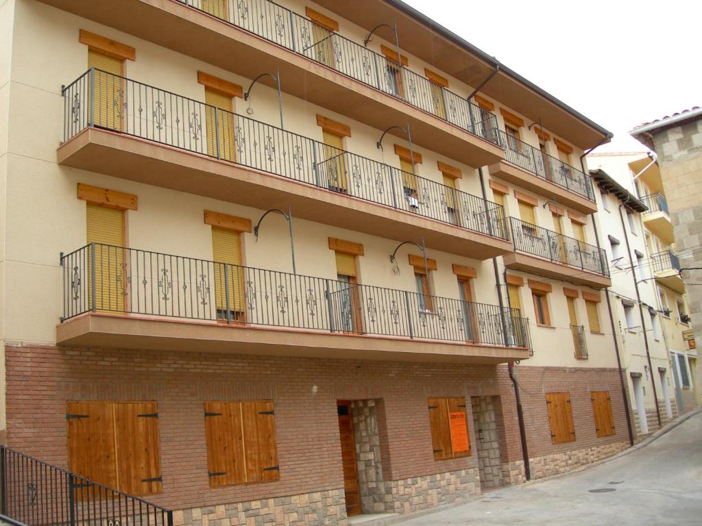 an apartment building with wooden balconies on a street at Apartamentos Turísticos Rosario in Camarena de la Sierra