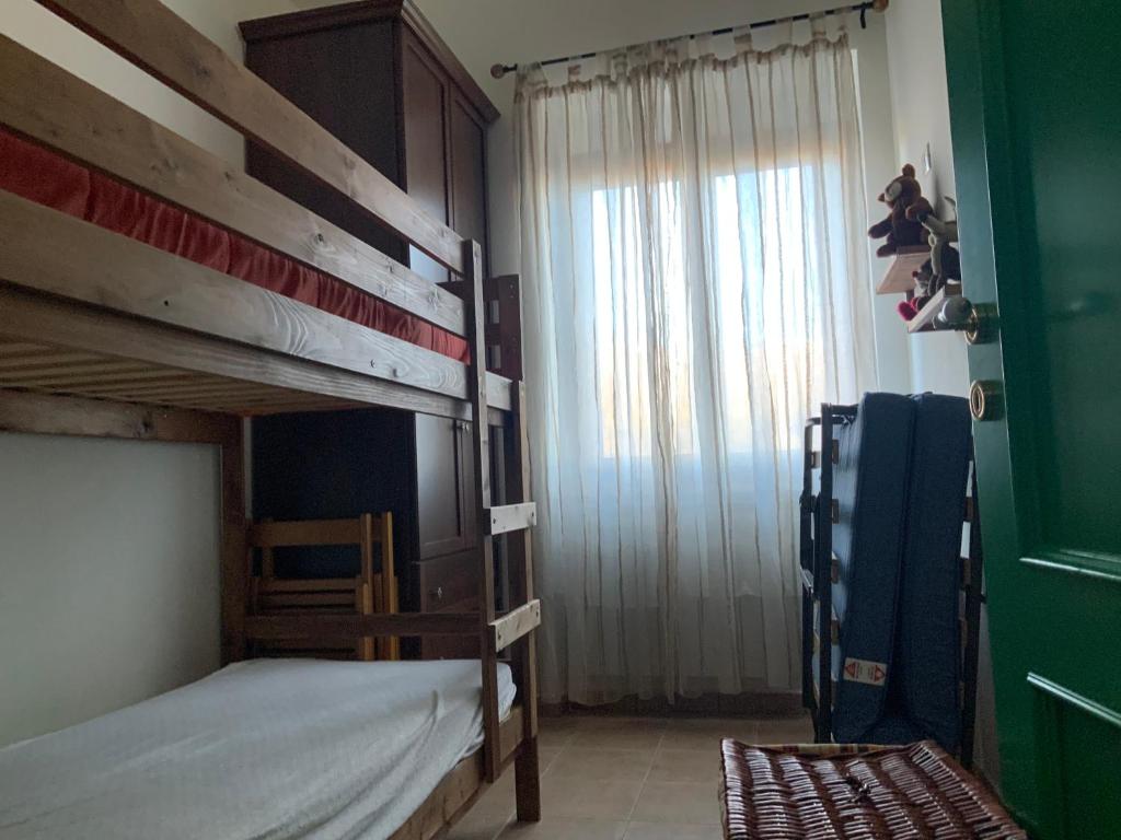 a bedroom with two bunk beds and a window at La casa nella Pinetina in Alfedena