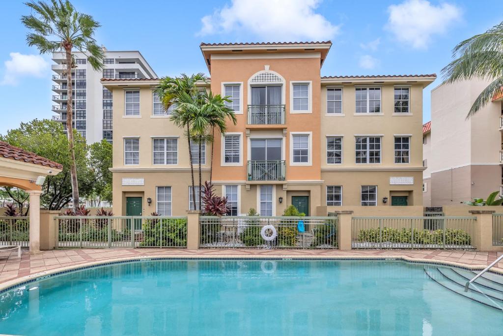 una villa con piscina frente a un edificio en Fantastic Townhouse Beach Access Resort Amenities!, en Hallandale Beach