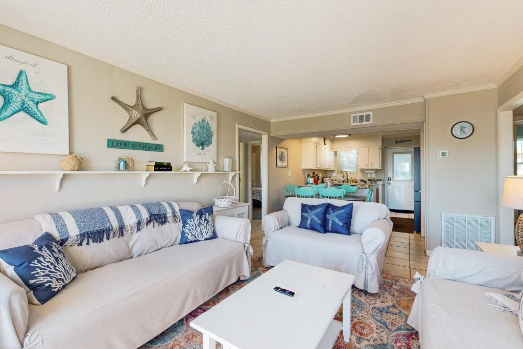 a living room with white couches and blue pillows at HB289 Feel the Burn in Holden Beach