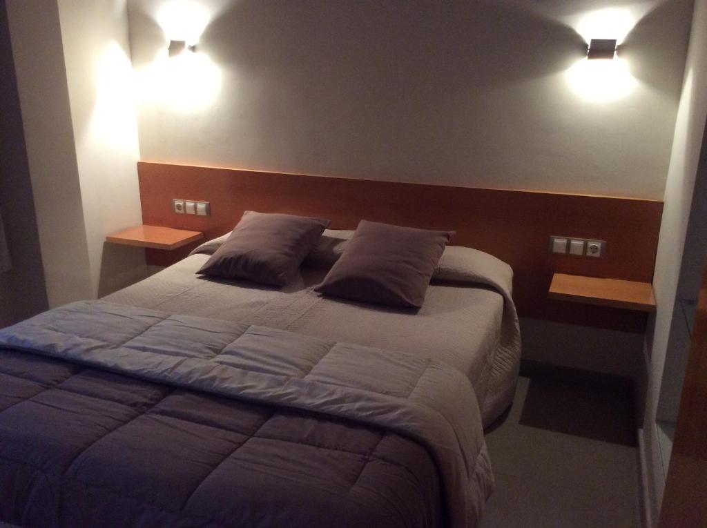 1 dormitorio con 1 cama grande y 2 almohadas en Hotel Viaurelia, en Montblanc