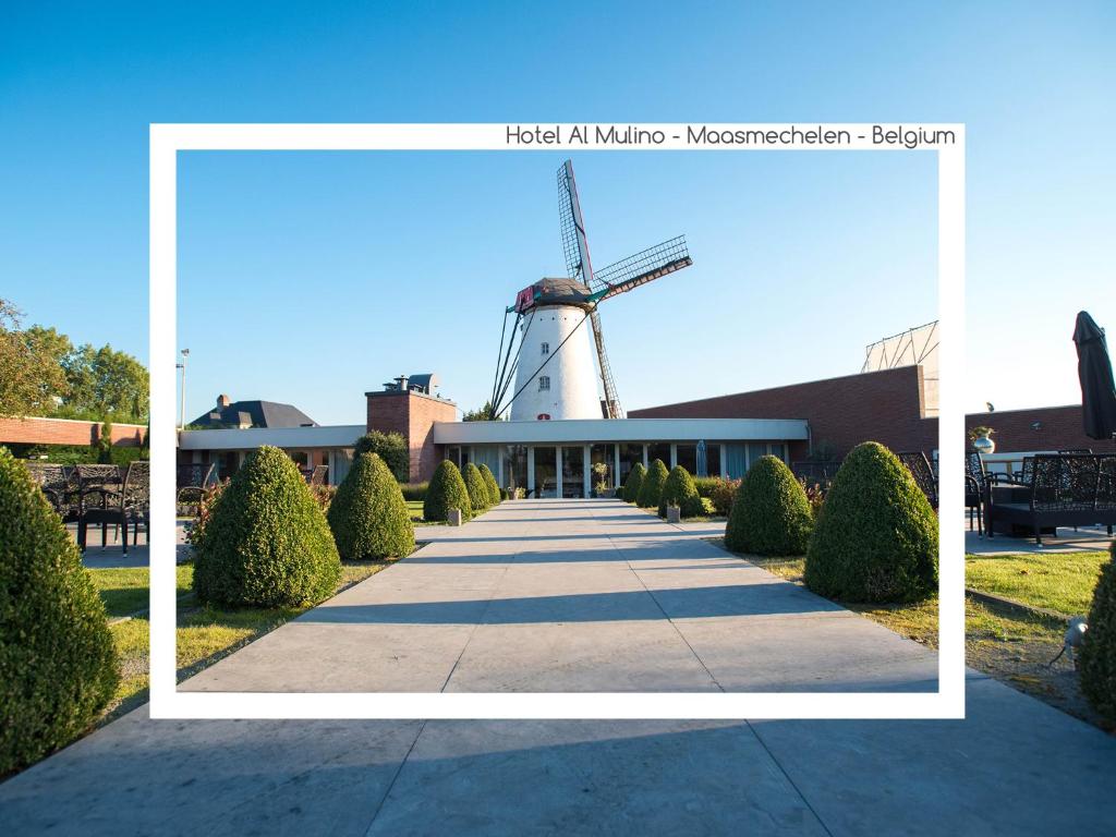 een foto van een windmolen voor een gebouw bij Hotel AL Mulino in Maasmechelen