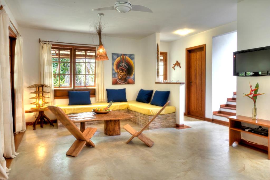ein Wohnzimmer mit einem gelben Sofa und einem Tisch in der Unterkunft Village Mata Encantada in Santo André