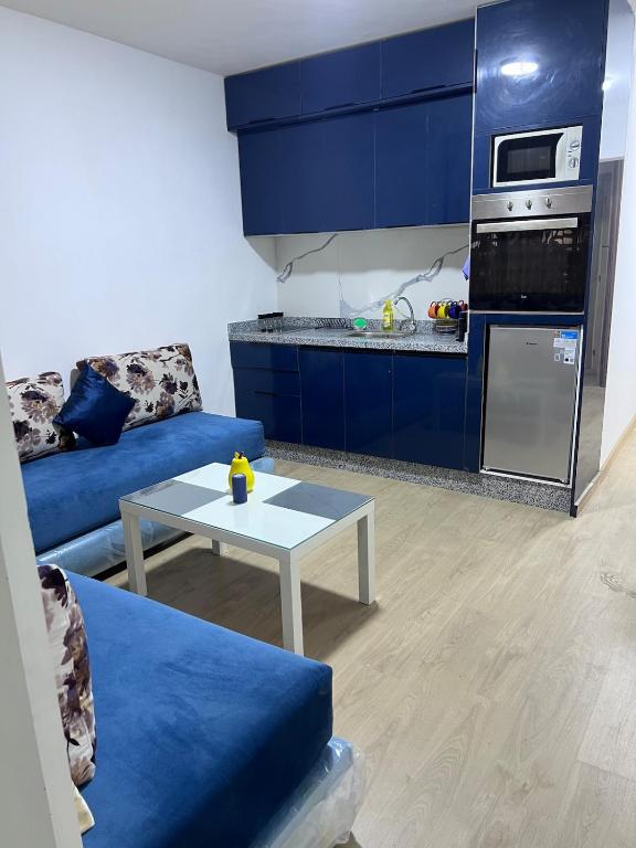 a living room with a blue couch and a table at Escapade à Fes in Fès