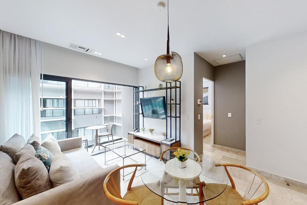 een woonkamer met een bank en een tafel bij Golden Wave Escape in Playa del Carmen