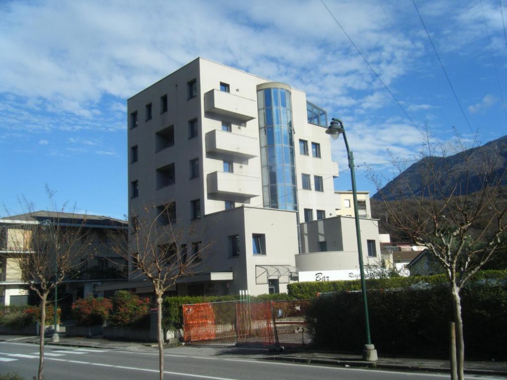 un edificio blanco alto al lado de una calle en Residence Vezzoli, en Darfo Boario Terme