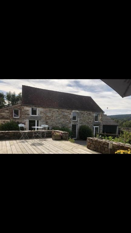 une grande maison en briques avec un grand toit dans l'établissement Meadow Brook Gites, à La Lande-de-Goult