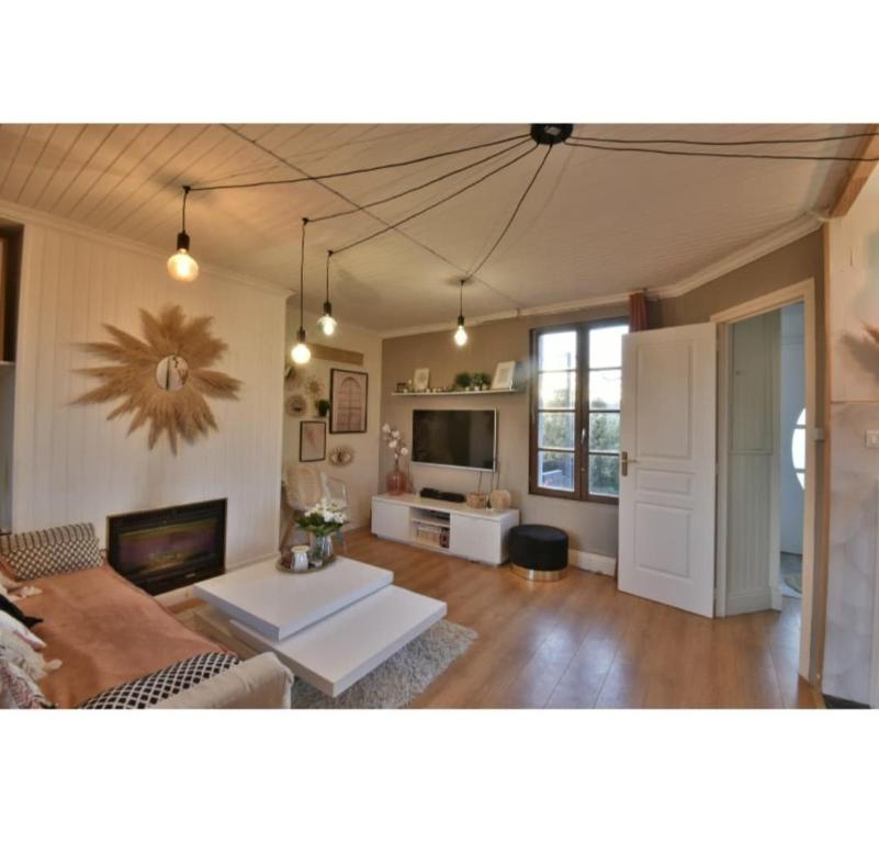 un salon avec un canapé et une table dans l'établissement Le cottage bohème, à Rimoux