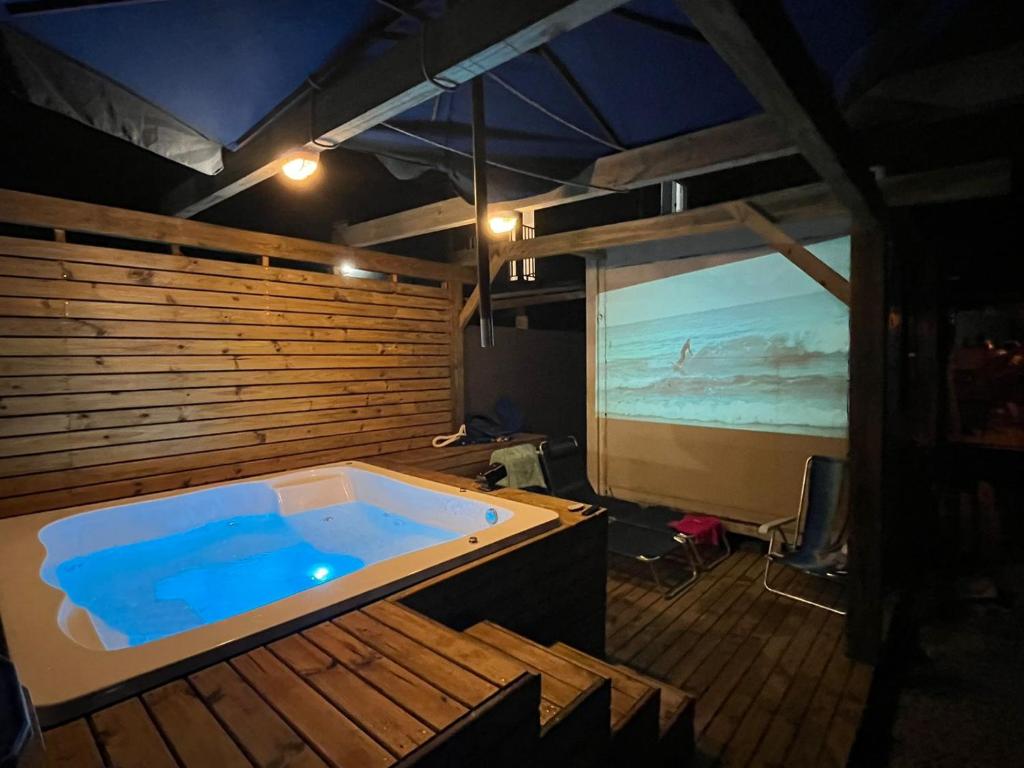 a large jacuzzi tub in a room with a screen at Studio Morro das Pedras Floripa com Jacuzzi in Florianópolis