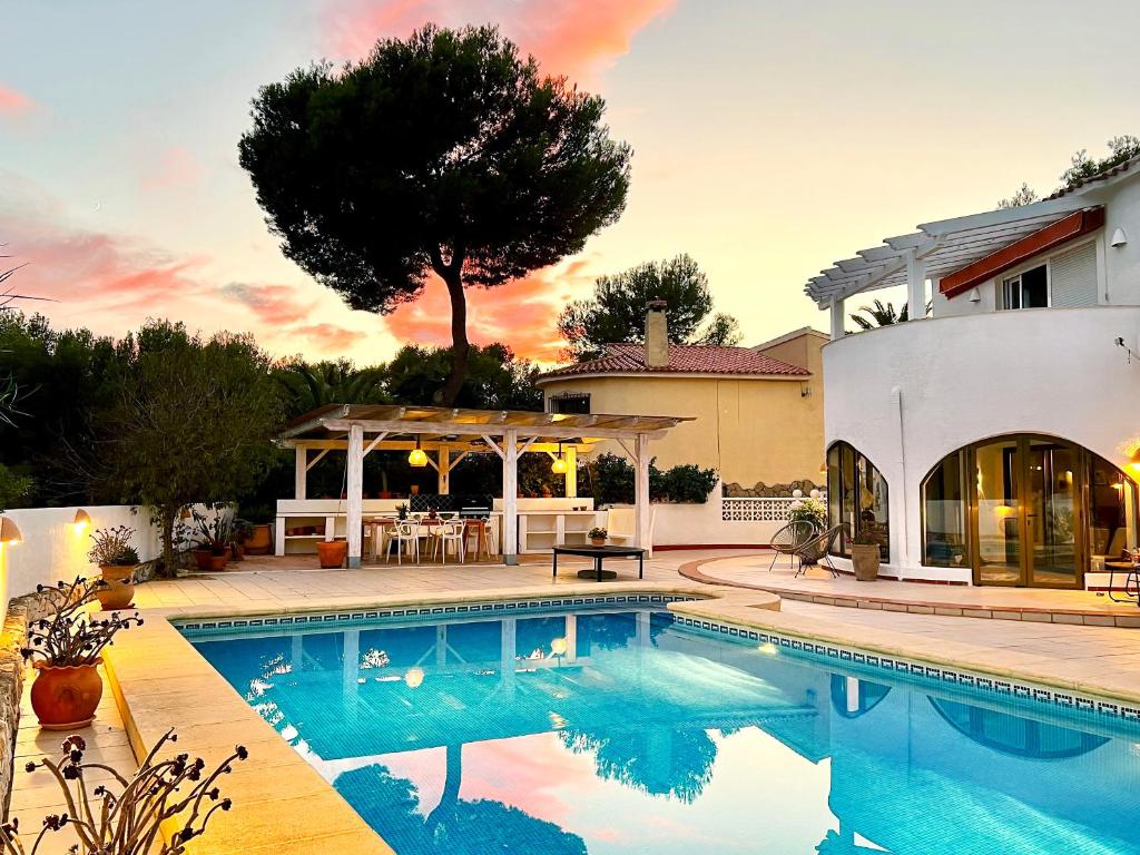 a swimming pool in front of a house at Casa Calma Moraira in Moraira