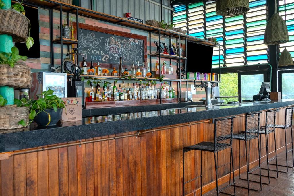 Un bar en un restaurante con un mostrador con alcohol. en Mayan Monkey Cancun - Social Hotel, en Cancún