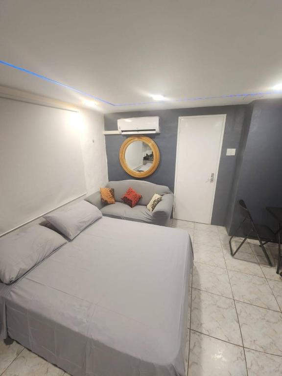 a bedroom with a large white bed and a mirror at A1 Apartments Aruba in Oranjestad