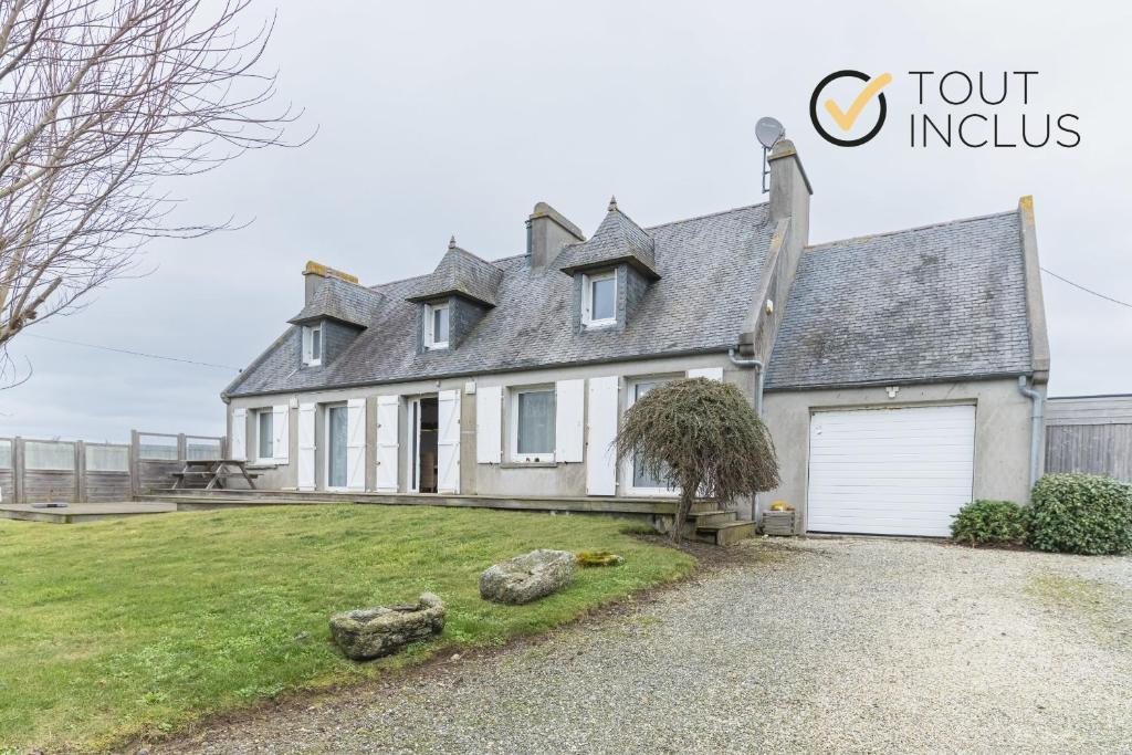 une grande maison blanche avec un garage blanc dans l'établissement TY CARN - Belle maison bretonne à 100m de la mer, à Ploudalmézeau