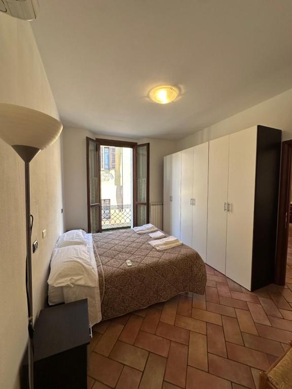 a bedroom with a bed and a large window at Aselli Palace in Cremona