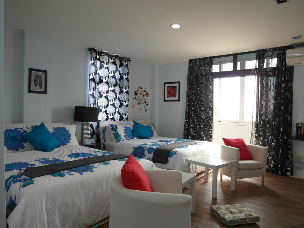 a bedroom with two beds and a table and chairs at Jia Mei Fa Homestay in Taitung City