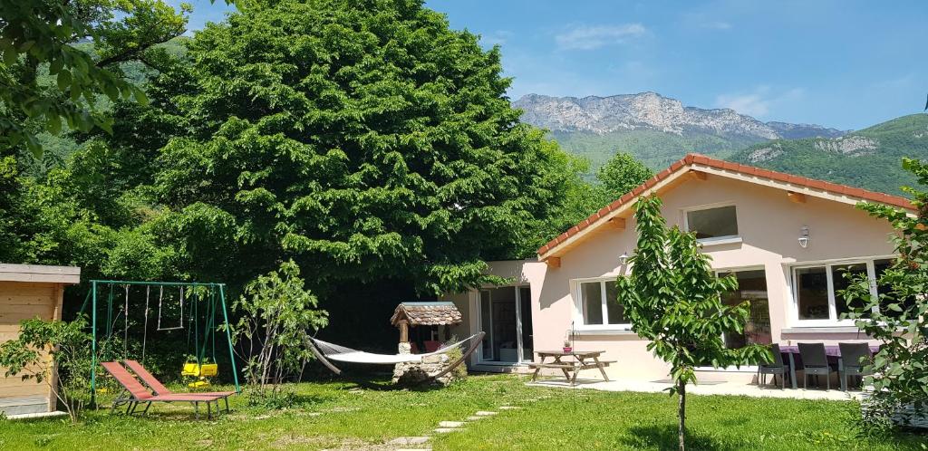 a house with a hammock in a yard at Villa fabuleuse l'Envolée Gites de Calistane in Saint-Vincent-de-Mercuze