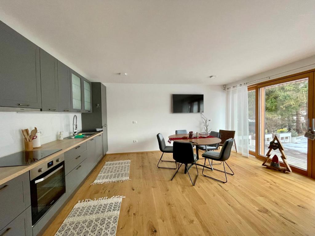 una cucina con tavolo e sedie e una sala da pranzo di Apartma Gorna a Kranjska Gora