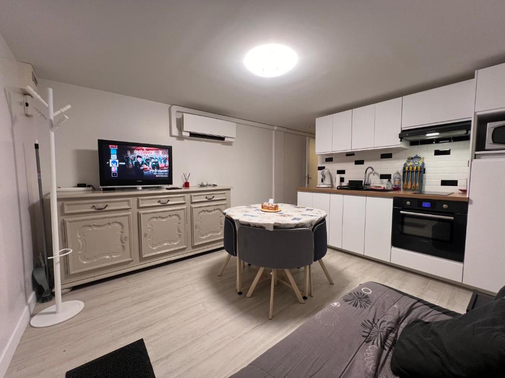 Il comprend une cuisine avec une table et une télévision. dans l'établissement Appartement T2 cosy proche de Paris, RER à 550m, à Yerres