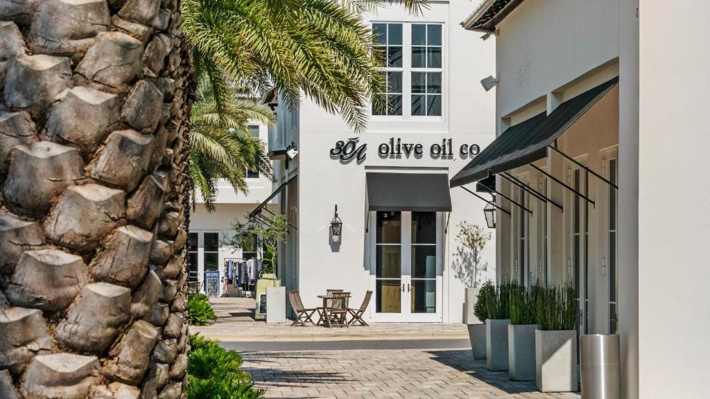 a facade of a white building with a stone wall at Lazy Days in Seacrest