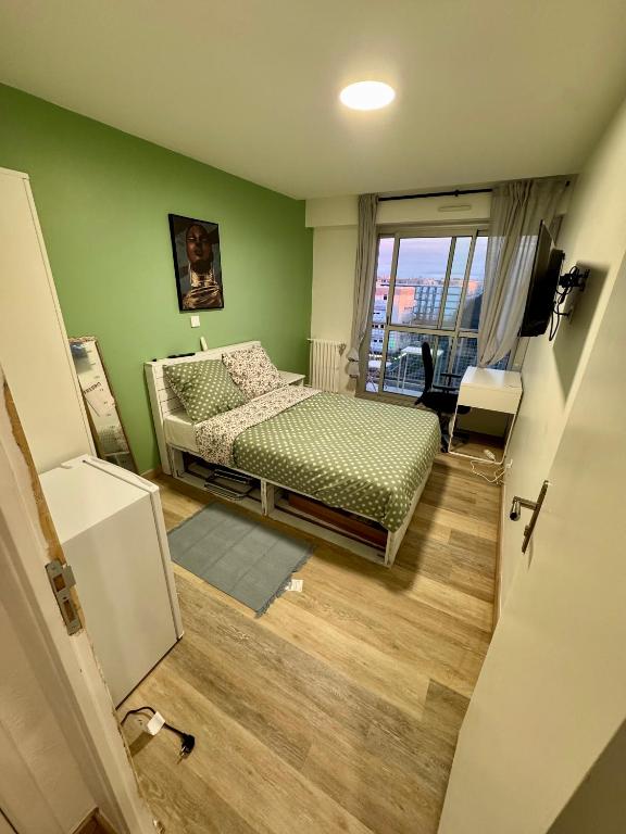une chambre avec un lit et un mur végétal dans l'établissement York's APPART, à Saint-Herblain